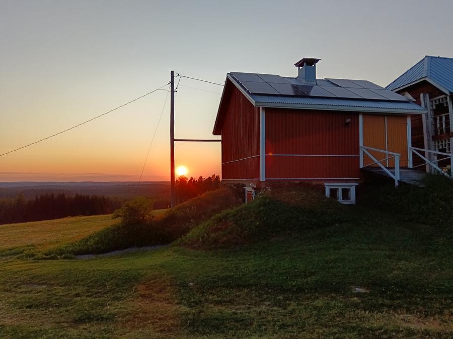 Kesäilta Koiramäellä, talousrakennus auringonlaskussa